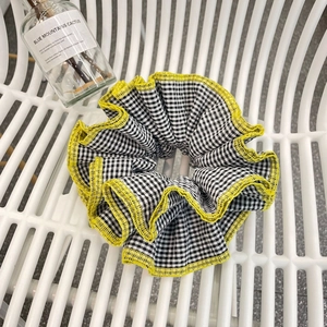 Plaid scrunchie with black and white grid pattern and neon yellow trim detailing