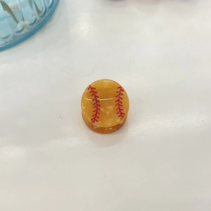 Vista detallada de la pinza redonda de acetato de béisbol amarillo con costuras rojas