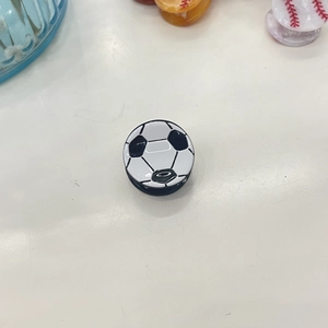 Detalle del soporte para móvil con forma de balón de fútbol y patrón en blanco y negro