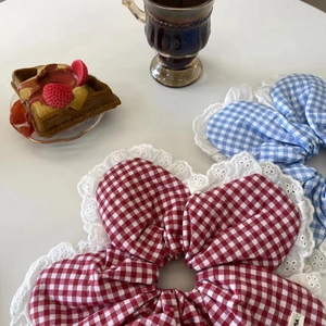 Detail of red and blue plaid scrunchies with white lace trim in a lifestyle tea setting