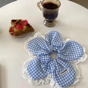 Blue and white plaid scrunchie with lace trim shown next to coffee and waffles