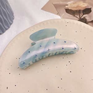 Pince à cheveux élégante en acétate bleu clair avec strass dans une assiette décorée