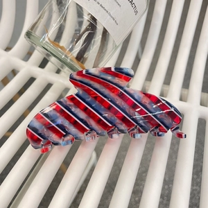 Détail macro de la grande pince à cheveux en acétate avec rayures rouges bleues et blanches