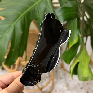 Pince à cheveux oiseau noire en acétate avec contours blancs et œil en cristal brillant