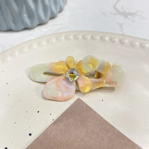 Fermaglio per capelli floreale in acetato con cristallo iridescente e scritta AMY BEAR
