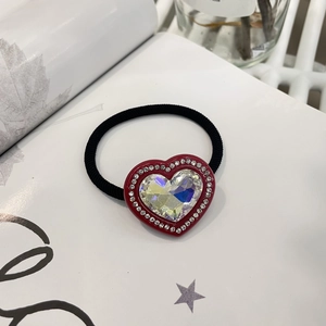 Détail de l'élastique à cheveux en forme de cœur avec gemme rouge et strass étincelants