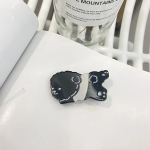 Détail d'une pince à cheveux panda mignonne avec finition polie et émail noir et blanc
