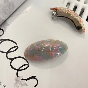 Detail of marble acetate spring hair clips set with silver metal back fastener