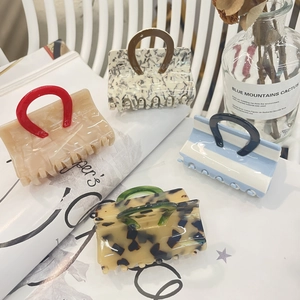 Détails macro des pinces à cheveux en acétate au design créatif de mini sacs à main