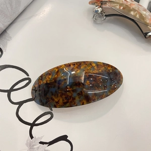 Detailed close-up of tortoise shell acetate hair clip with premium spring metal clasp