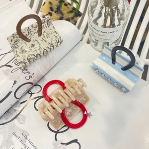Lot de quatre pinces à cheveux en acétate aux motifs variés sur des magazines de mode