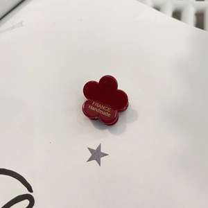 Détail d'une pince à cheveux fleur rouge foncé avec lettrage doré France Handmade gravé