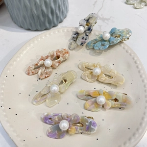 Macro shot of assorted butterfly acetate hair clips with pearls and marble textures