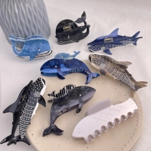 Macro shot of colorful acetate ocean animal hair claws including whale and shark designs