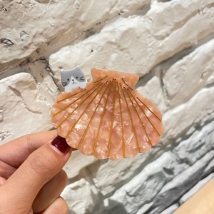 Détail de la pince à cheveux en acétate rose marbré avec chat et lignes dorées fines