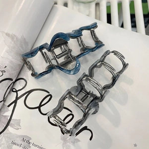 Elegant wave-shaped acetate hair claws in blue marble and smoky grey ink patterns