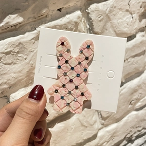 Détail d'une barrette lapin rose effet marbre ornée de strass colorés étincelants
