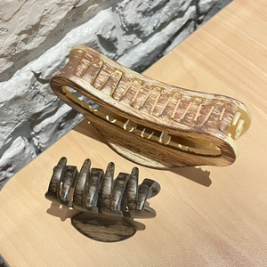 Detail of wood grain hair claws in large light beige and small dark brown sizes