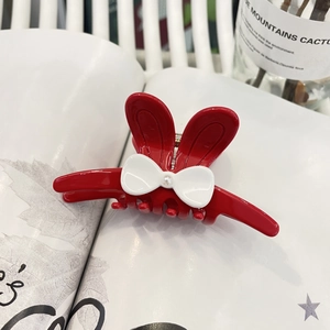 Pince à cheveux oreilles de lapin rouges avec nœud blanc et perle sur fond de magazine