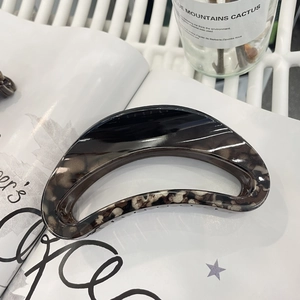 Elegant large tortoiseshell claw clip made of acetate on a fashion magazine background