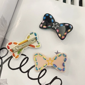 Detail of star-themed plush bow hair clips with decorative stitching and metal springs