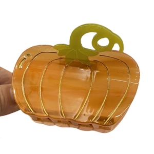 Creative pumpkin-shaped acetate hair claw clip with orange translucent finish and gold glitter