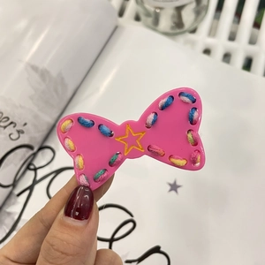 Pink plush star hair clip with colorful stitching and yellow star accent for women