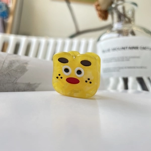 Pince à cheveux monstre jaune en acétate avec visage cartoon et texture marbrée