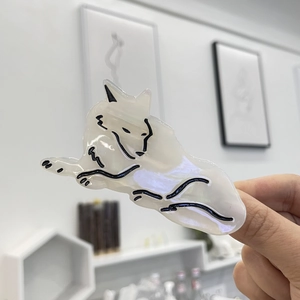 Detail of cream-colored acetate cat hair claw clip showing glossy pearlescent finish