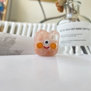 Détail de la pince à cheveux monstre en résine rose marbrée avec décor artistique