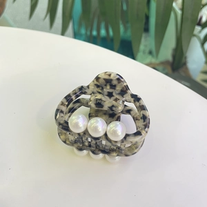 Detail of tortoise shell acetate hair claw with large pearls and gold Amy Bear branding