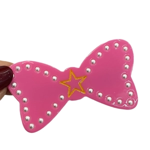 Pink bow hair clip with golden star and white pearls in a cute Y2K dopamine style