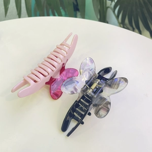 Detailed macro view of colorful acetate butterfly hair claws with metal spring mechanism