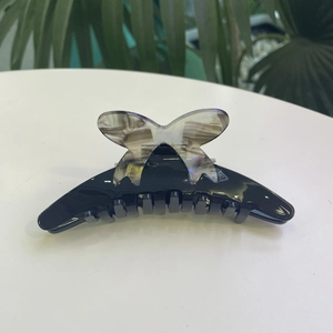 Elegant black acetate hair claw clip with a marble butterfly pattern for women's hairstyling