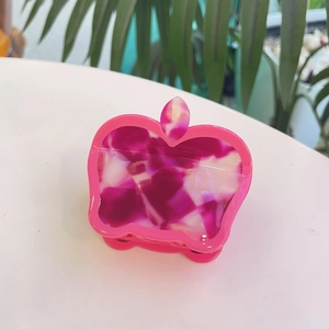 Pink apple-shaped hair claw clip made of marbled acetate with leaf detail for women