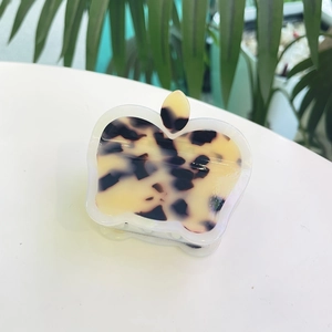 Macro view of apple-shaped hair claw clip with tortoiseshell pattern and leaf detail
