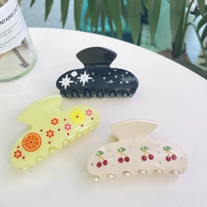 Detailed set of three acetate hair claws featuring cherry, lemon, and starry rhinestone patterns