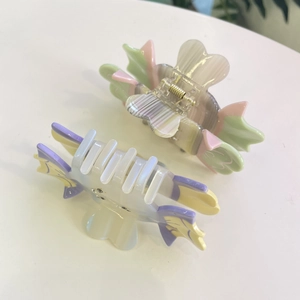 Detail of two acetate butterfly hair claws with colorful marble texture and crystals