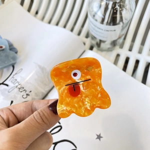 Vue détaillée de la pince à cheveux monstre orange en acétate avec marbrures