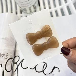 Pair of minimalist light brown translucent resin bow hair clips on display card