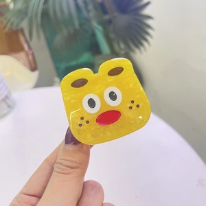 Détail de la pince à cheveux monstre jaune style y2k en acétate avec texture marbrée
