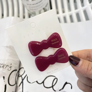 Pair of jelly wine red duckbill hair clips with handmade gold lettering on display card