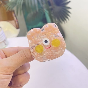 Détail d'un support de téléphone ours rose translucide avec paillettes et visage souriant