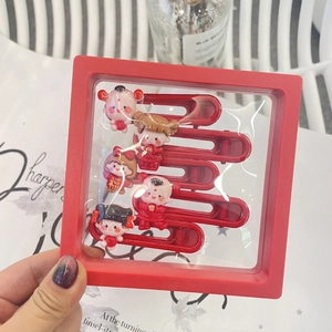 Detail view of five red cartoon hair clips with Fu character in a red display gift box