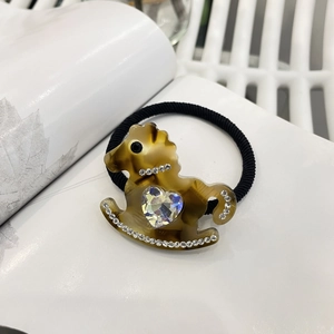 Close-up of y2k hair tie featuring a tortoiseshell rocking horse with crystal heart detail