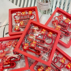 Detail of red Chinese New Year hair clips with Maneki-neko and lucky pouch designs