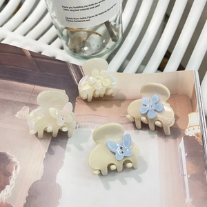 Dettaglio di un set di quattro mini mollette per capelli in acetato con farfalle e fiori