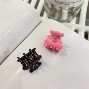 Détail de deux mini pinces à cheveux ours en acrylique rose et marron avec strass