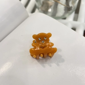 Détail de la pince à cheveux ours en acétate ambré avec strass et motif cœur