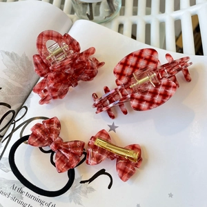 Détail d'un lot de quatre accessoires cheveux à carreaux rouges et pinces dorées